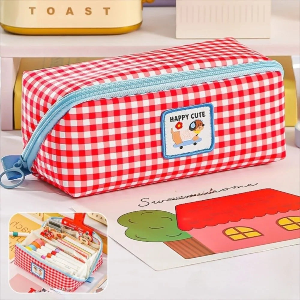 Red and white kawaii checkered pencil case with blue zipper on a light surface.