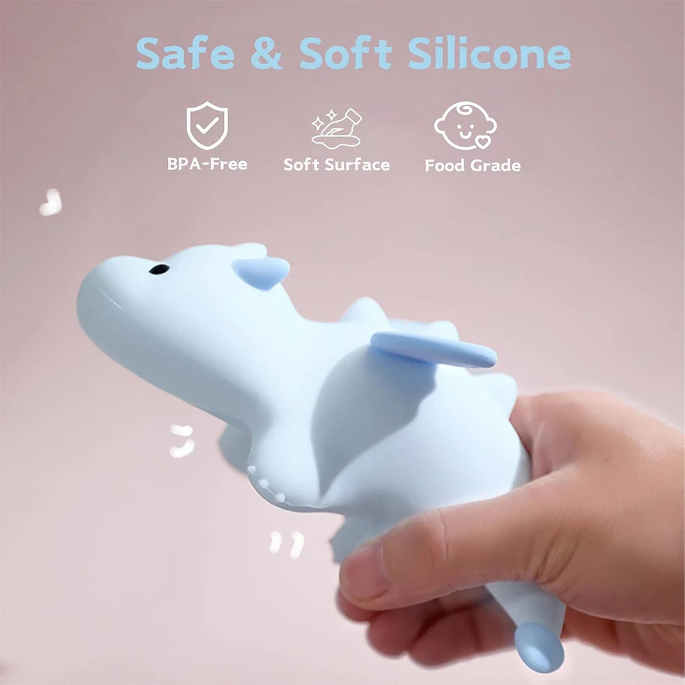Silicone toy shaped like a kawaii whale held by a hand with safety features highlighted on a pink background.
