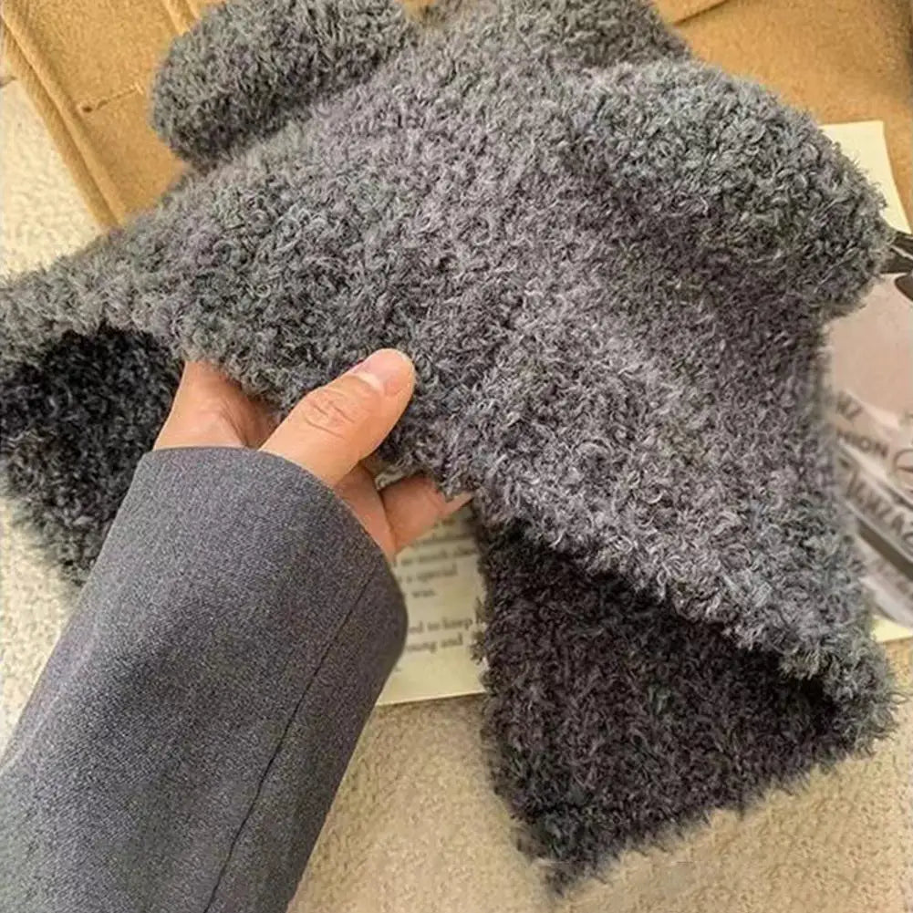 Gray plush Kawaii hat held by a hand on a carpeted floor