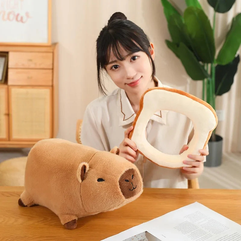 Person holding a kawaii plush toy shaped like a slice of bread and a piggy bank on a wooden table.