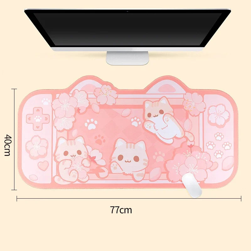 Pink desk mat with Kawaii cat designs and measurements on a beige background