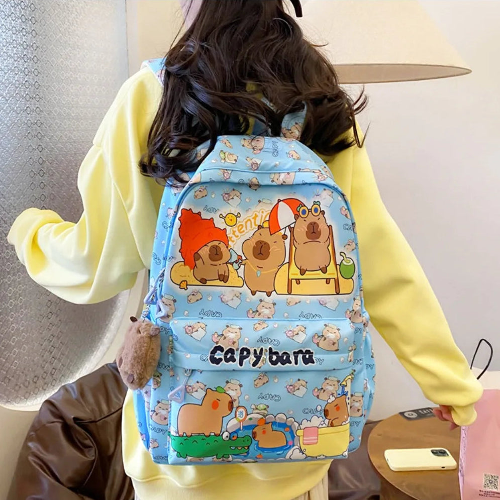Person wearing a blue Kawaii Capybara-themed backpack with cartoon designs.