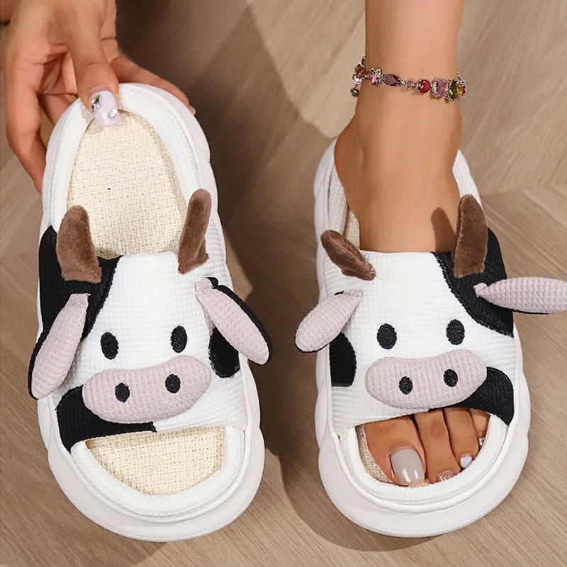Cow-themed kawaii slippers worn on a wooden floor