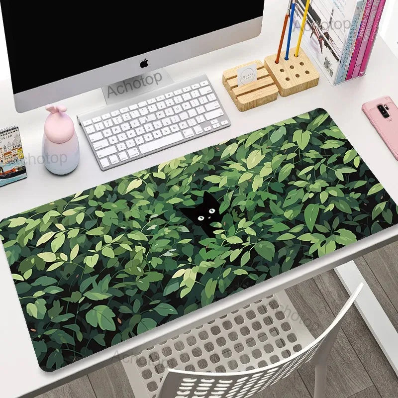 Desk setup with a Kawaii green leaf-patterned mouse pad featuring a black cat.