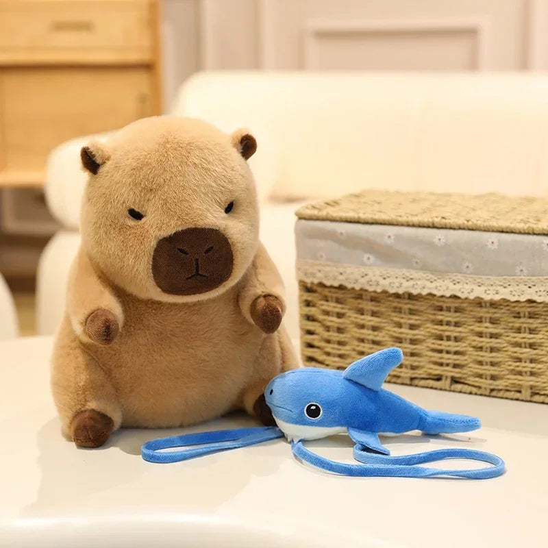 Kawaii plush toy otter with a plush shark toy on a light-colored surface.