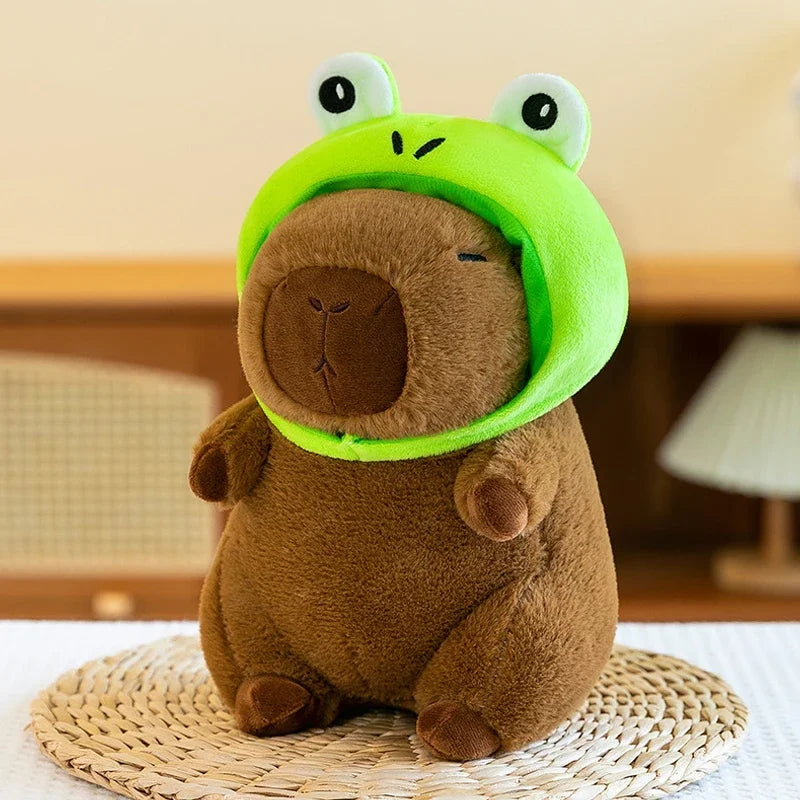 Kawaii plush toy resembling a brown animal with a green frog helmet on a woven mat.