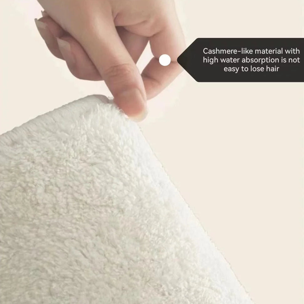 Hand touching a textured white kawaii fabric with a label indicating cashmere-like material and high water absorption.