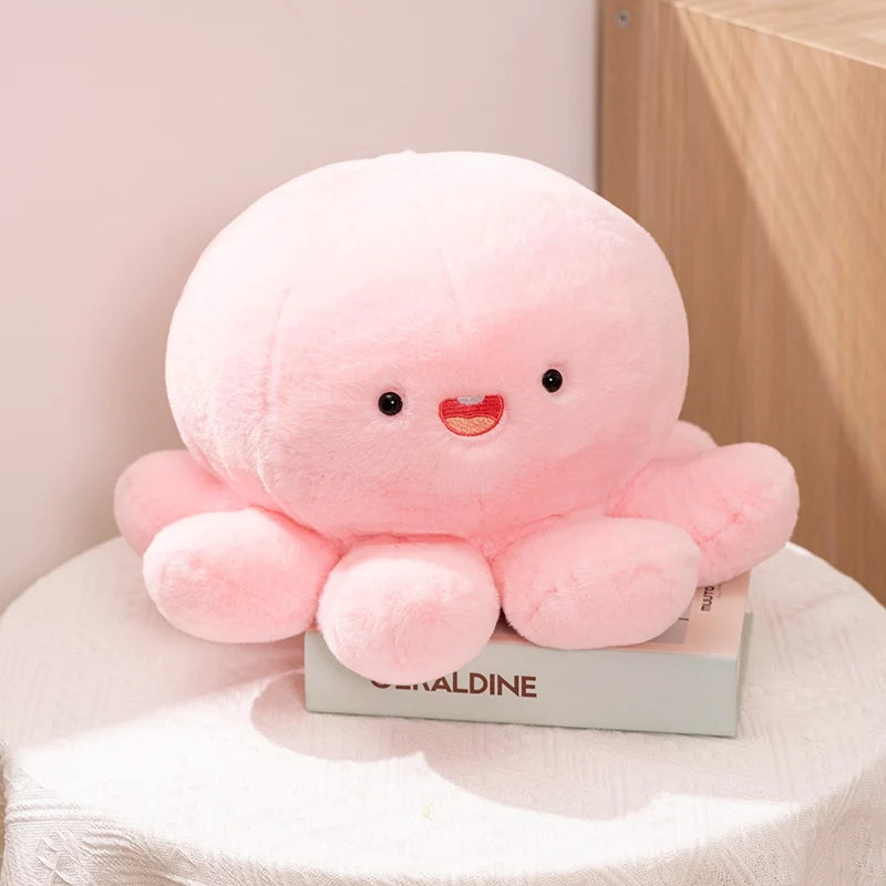 Pink kawaii plush octopus toy on a white surface with a light pink background