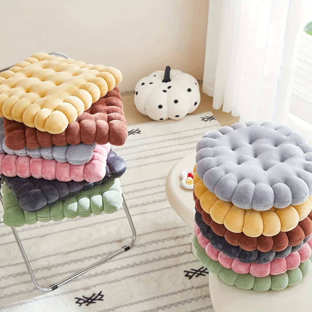 Stacked colorful kawaii cushion on a stool in a room with a pumpkin decoration.