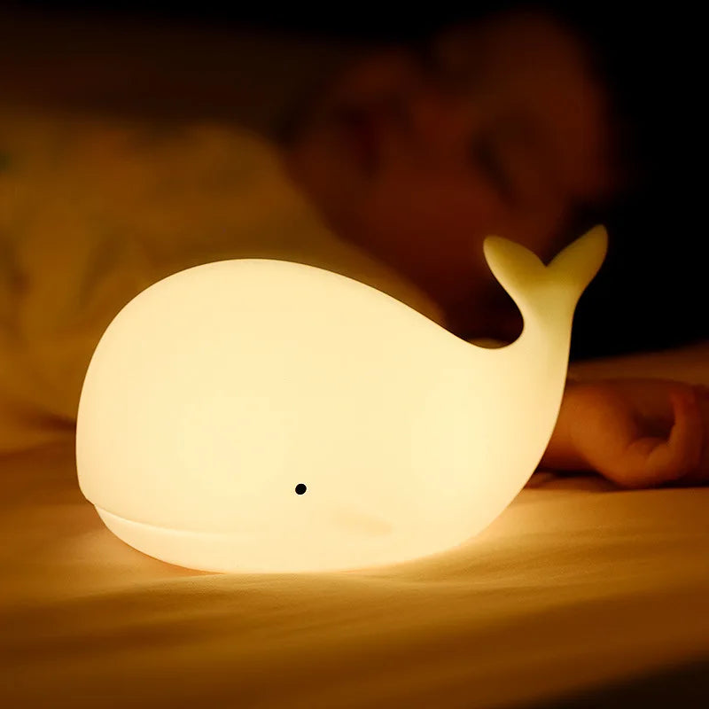 Whale-shaped kawaii night light on a surface with a blurred background