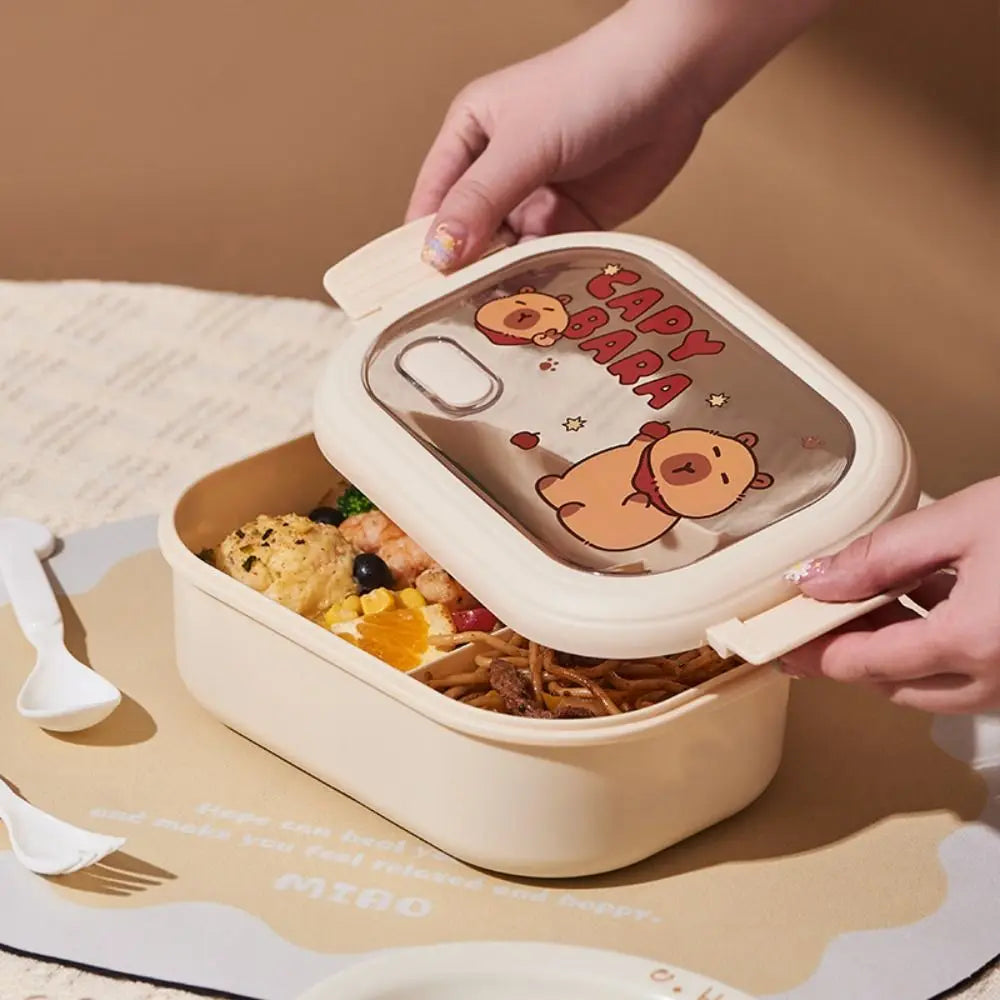 Lunch box with kawaii cartoon design held by a hand on a beige surface