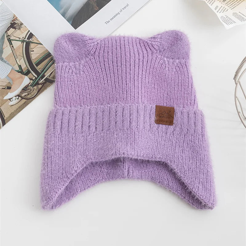 Purple knit Kawaii beanie with a brown label on a white surface
