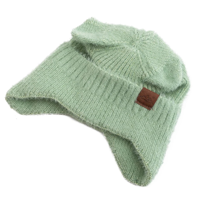 Green knit Kawaii beanie with a brown label on a white background