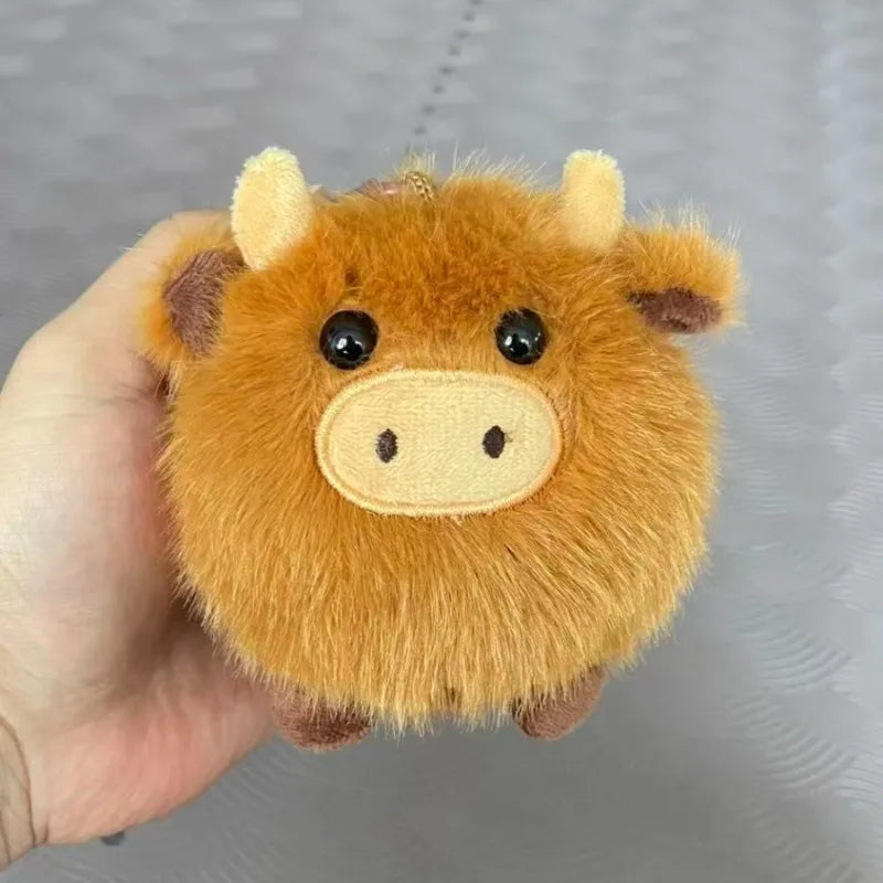 Plush kawaii toy cow held in a hand against a gray background