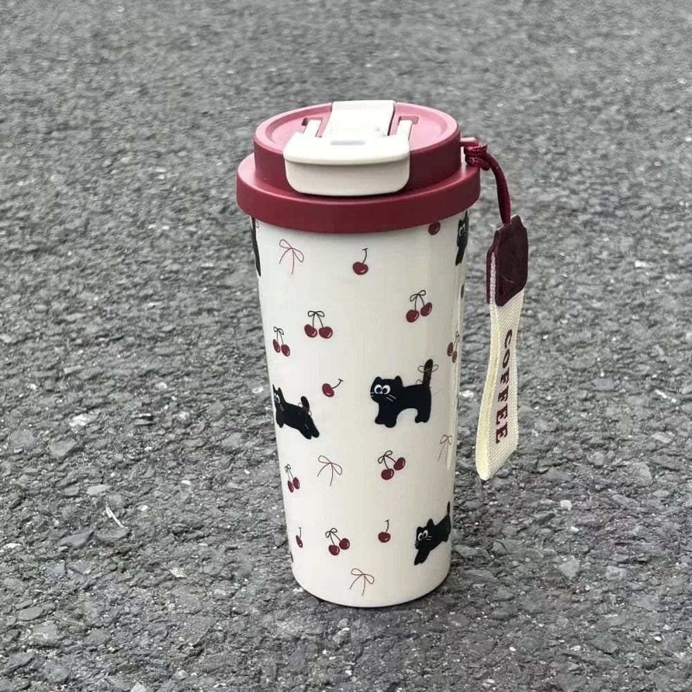 Travel mug with Kawaii cherry and cat pattern on a textured surface