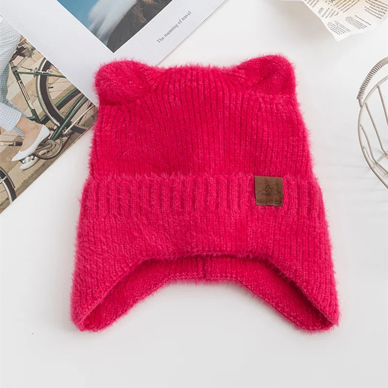Red knitted Kawaii hat with a brand label on a white surface