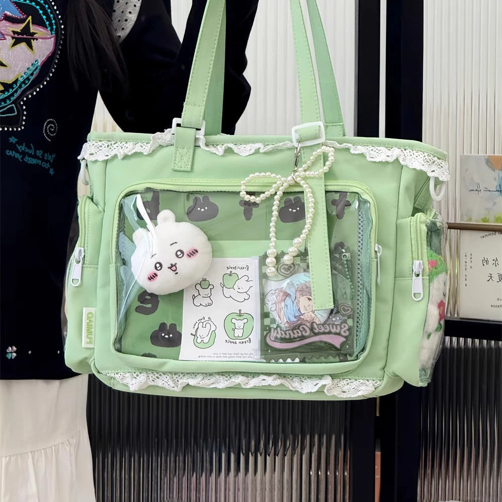 Green Kawaii handbag with transparent front pocket, rabbit plush toy, and decorative elements held by a person.