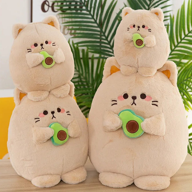 Two kawaii plush toys resembling cats with green and brown accents on a wooden surface with a leafy background.