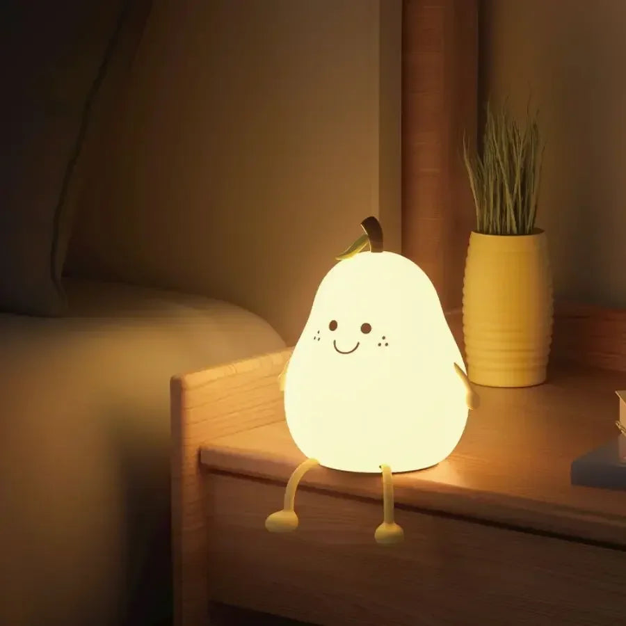 Cute kawaii night light shaped like a pear on a bedside table with a plant in the background.