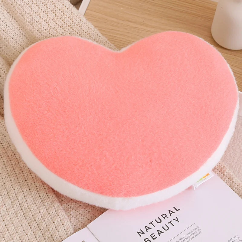 Heart-shaped pink kawaii cushion on a textured surface with a magazine underneath