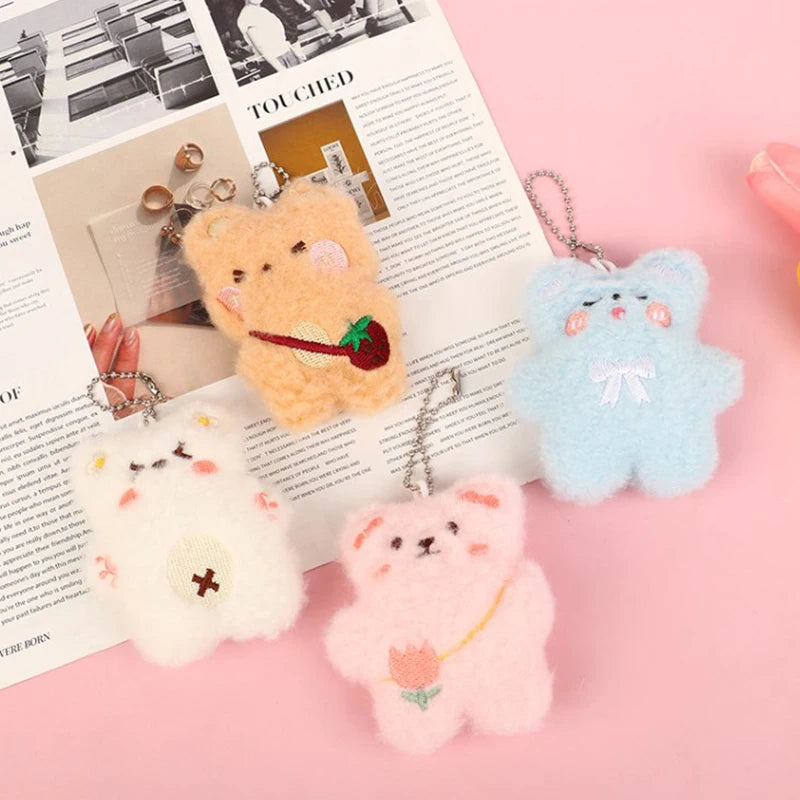 Four kawaii cute bear-shaped keychains on an open magazine with a pink background