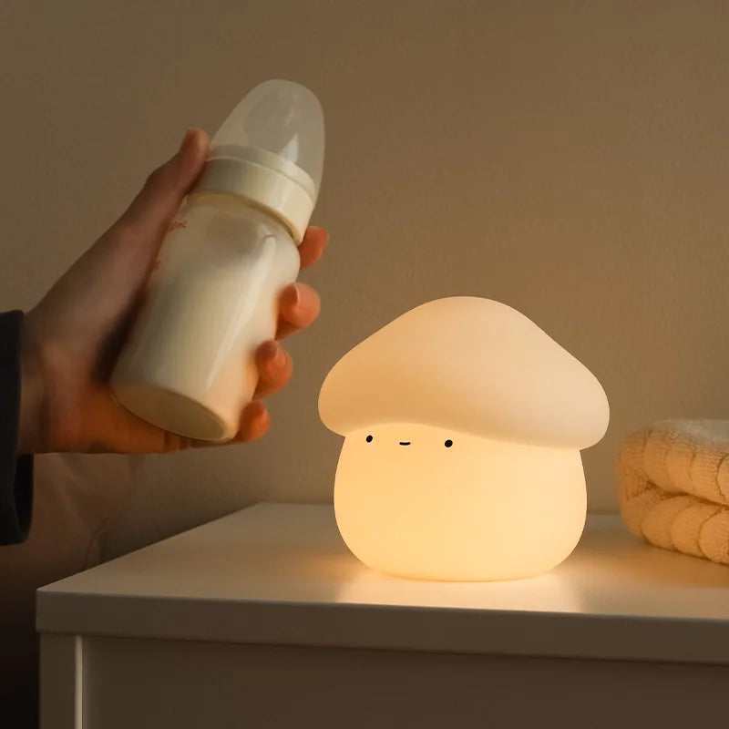 Mushroom-shaped kawaii night light on a surface with a hand holding a bottle nearby.