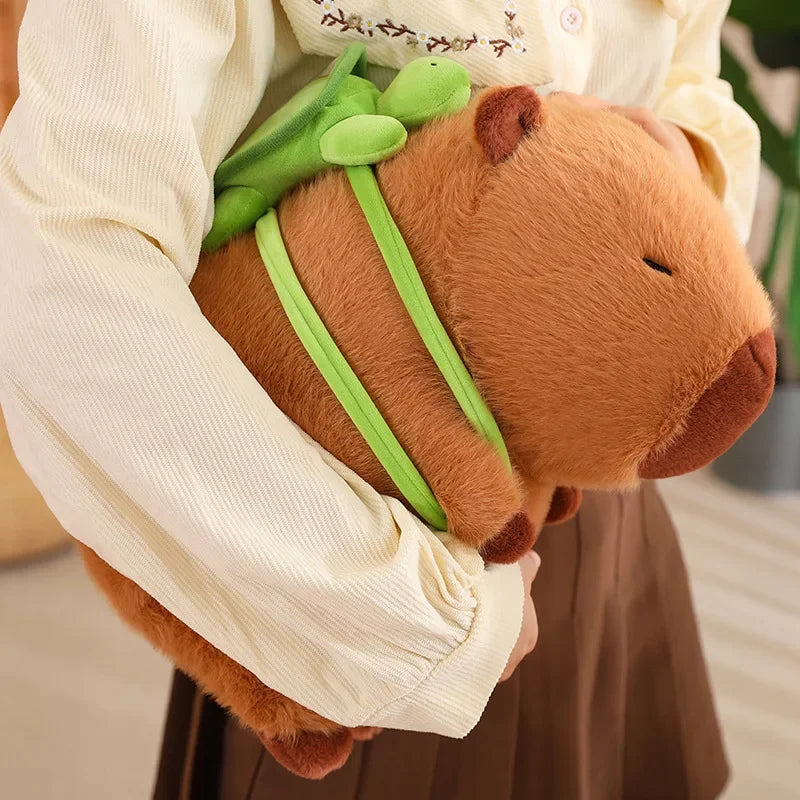 Person holding a kawaii plush toy with green straps and a brown bear-like face.
