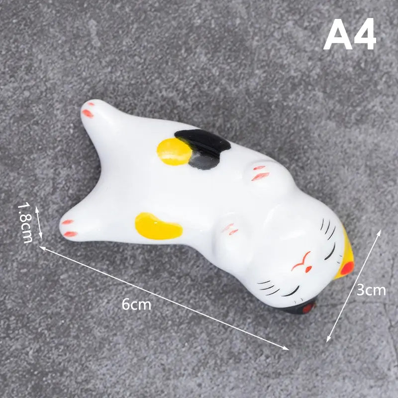 White kawaii cat-shaped object with black and yellow accents on a gray background, showing measurements.