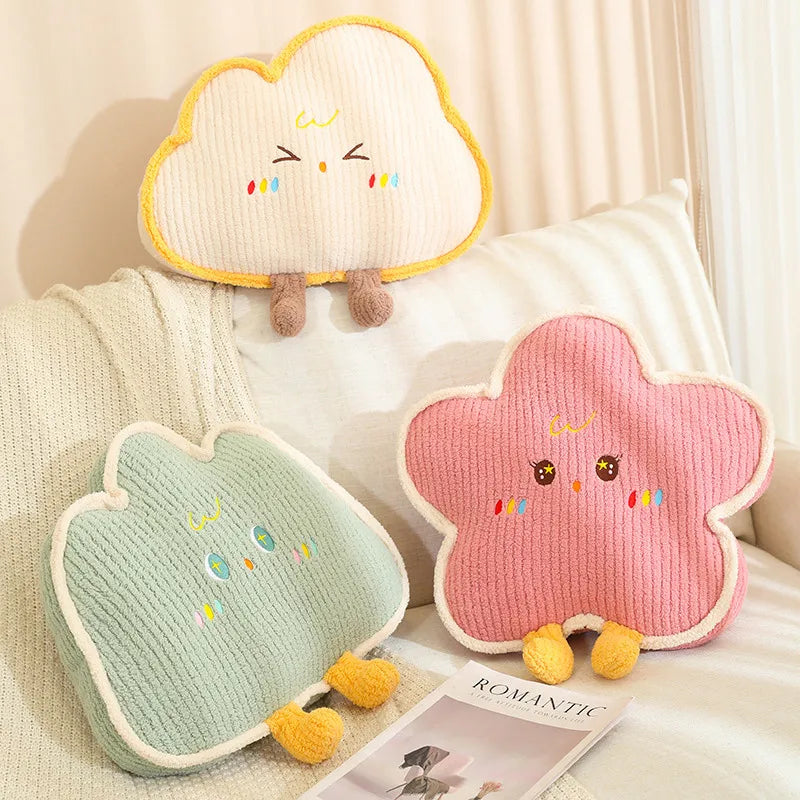 Three cloud-shaped kawaii cushions with cartoon faces on a bed