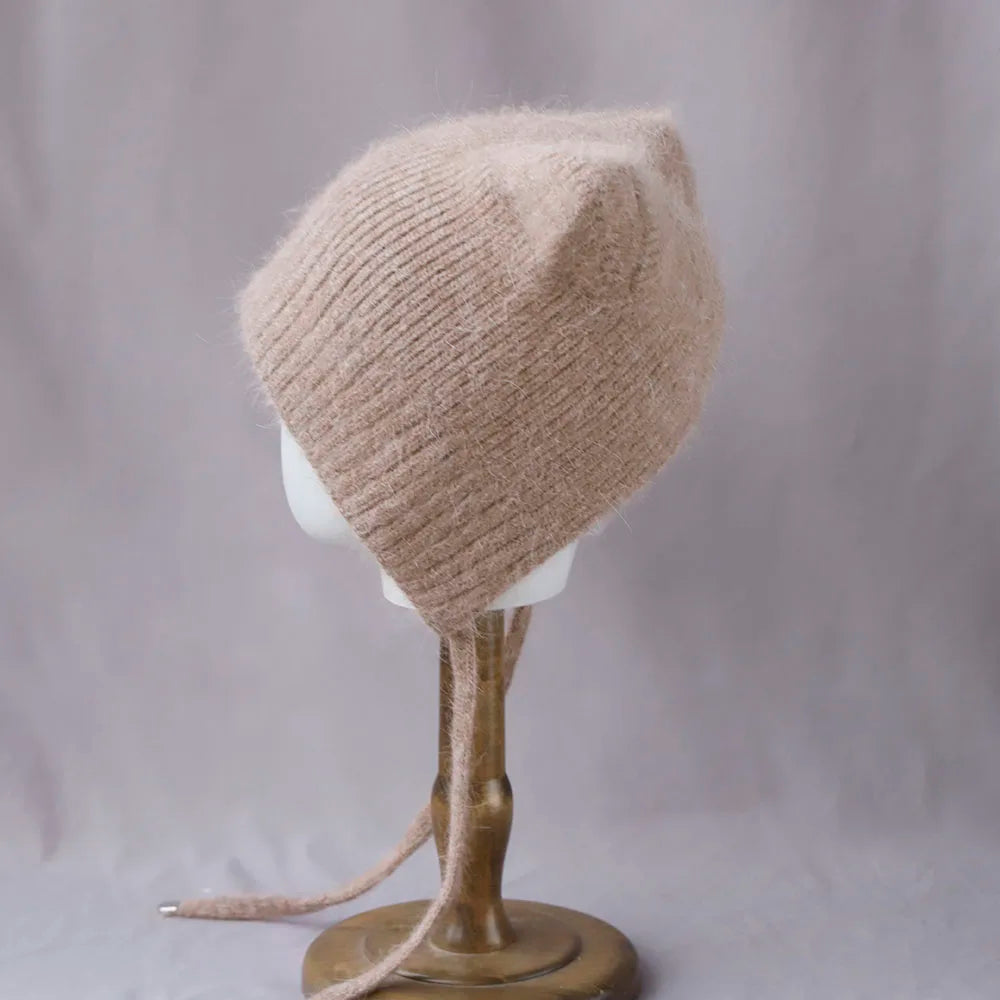 Beige knitted Kawaii hat on a mannequin head against a plain background