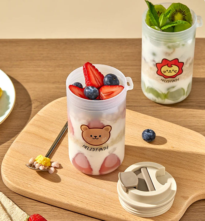 Clear plastic cups with Kawaii bear designs filled with fruit on a wooden surface