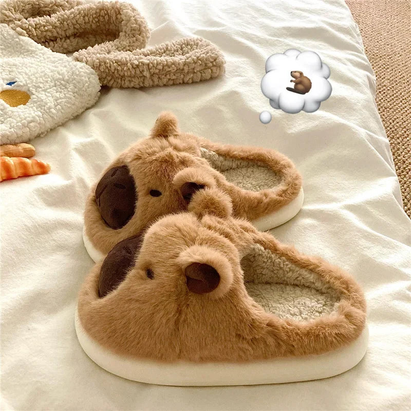 Pair of brown dog-shaped kawaii slippers on a white surface with a thought bubble containing a small brown dog icon.