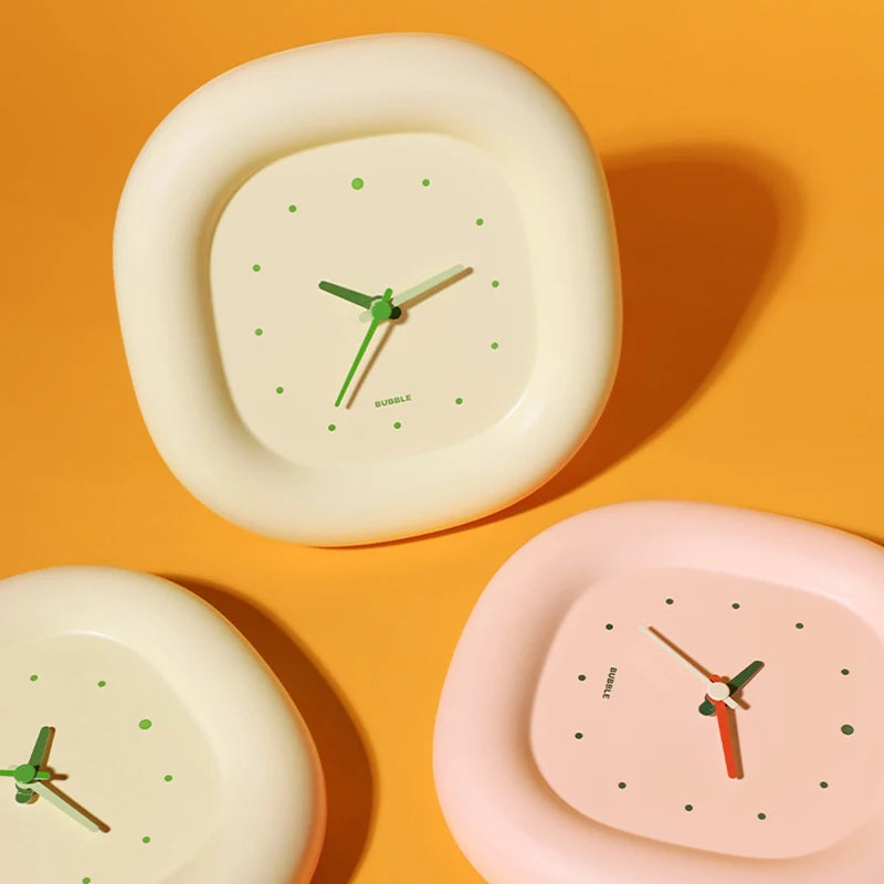 Three round kawaii clocks with different colors on an orange background