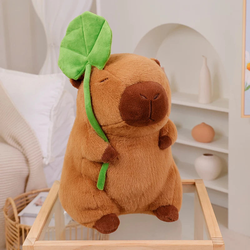 Kawaii plush toy resembling a beaver with a green leaf on a glass table