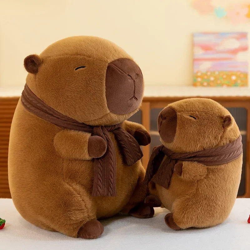 Two brown kawaii plush animals with scarves sitting on a white surface.