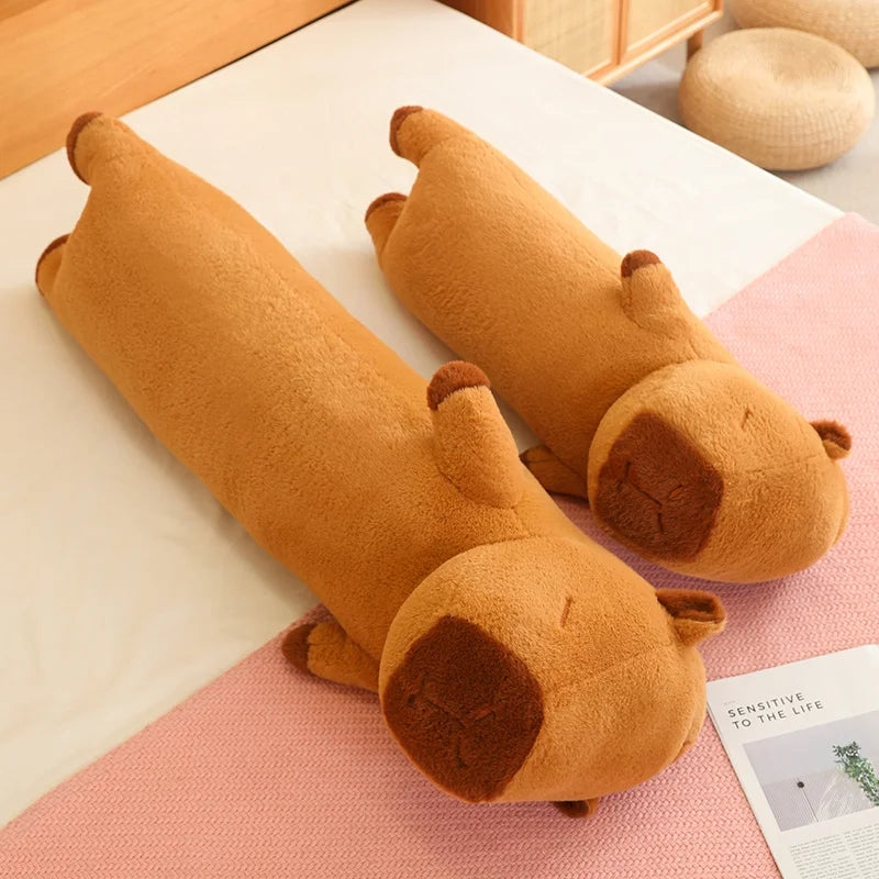 Two brown dog-shaped body kawaii pillows on a checkered surface with a magazine.