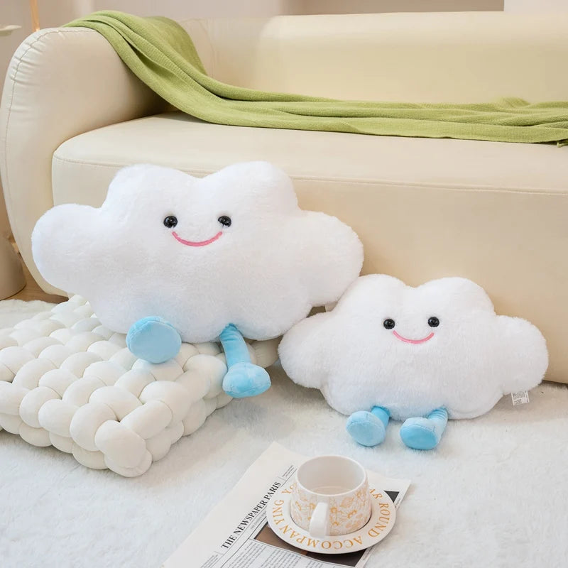 Two cloud-shaped kawaii plush toys on a couch with a cup and newspaper.