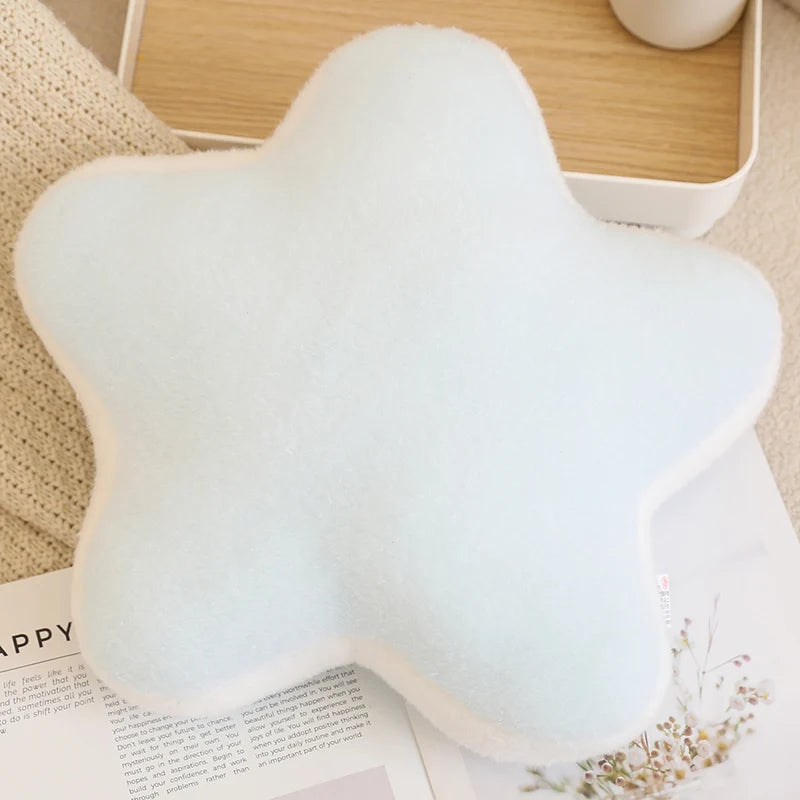 Star-shaped white kawaii pillow on a wooden surface with a magazine underneath