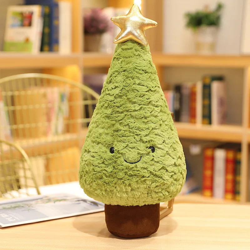 Green plush kawaii toy shaped like a Christmas tree with a star on top, sitting on a surface with a bookshelf in the background.