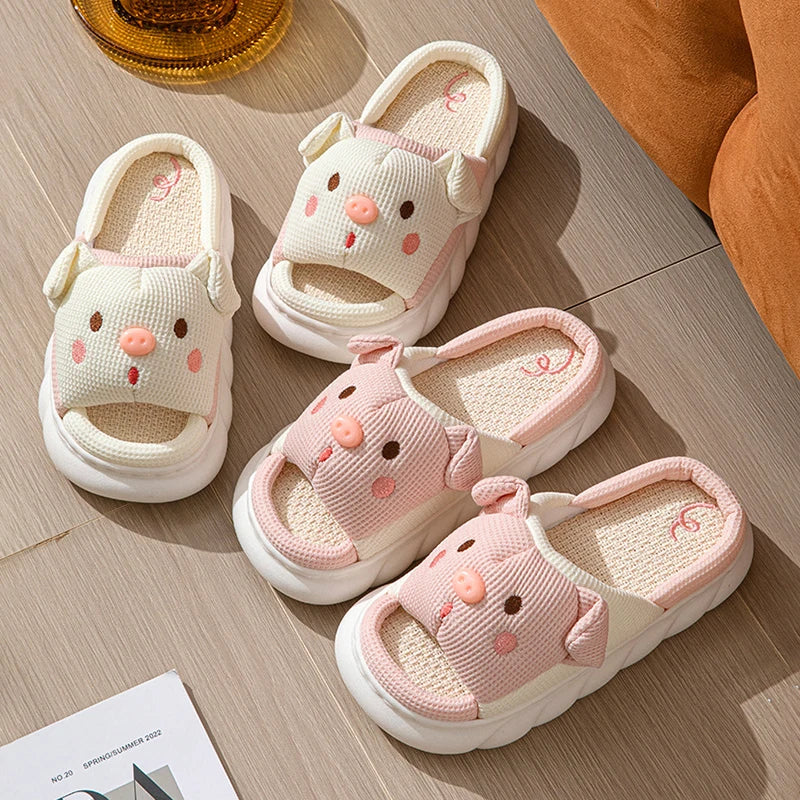 Pair of pink kawaii children's sandals with cartoon face design on a wooden floor.