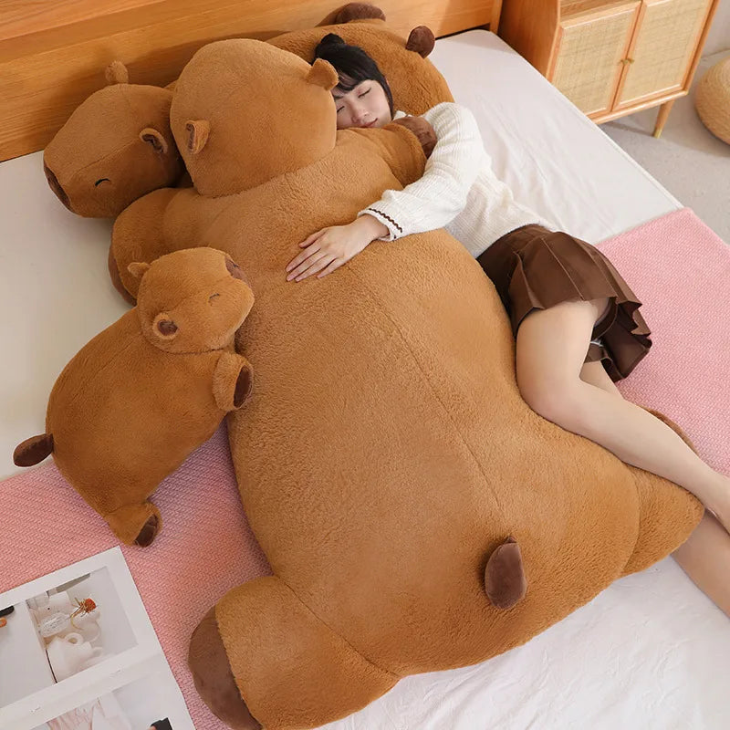 Person lying on a bed with a large brown kawaii teddy bear