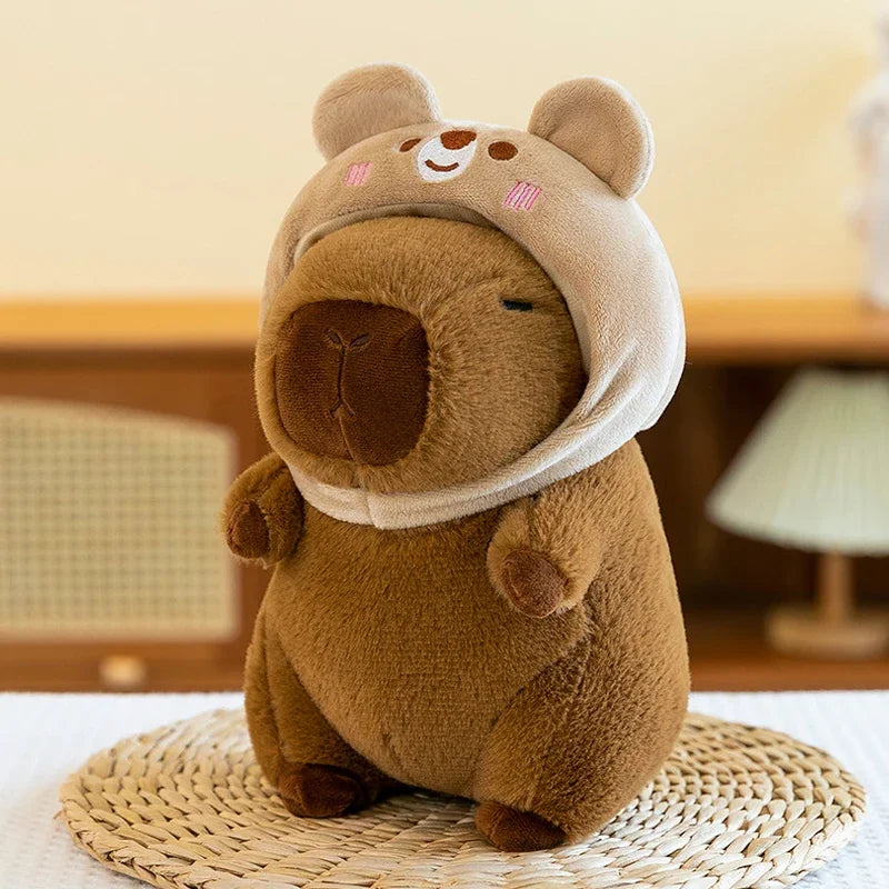 Brown kawaii plush bear toy with a white hood on a woven mat