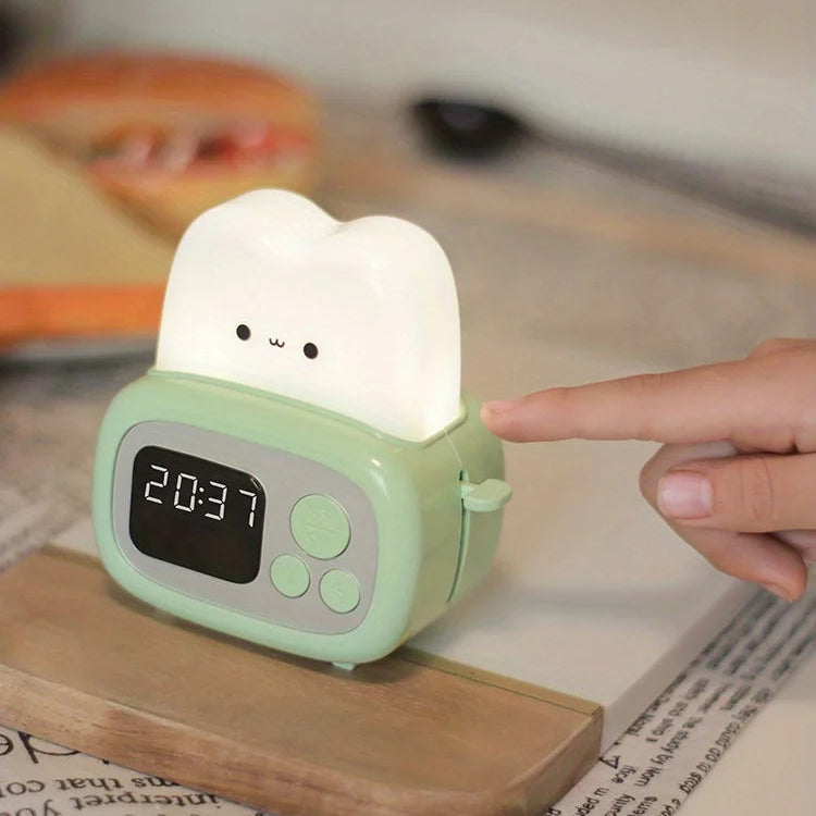 Cute green kawaii alarm clock with a cartoon face on a wooden surface.