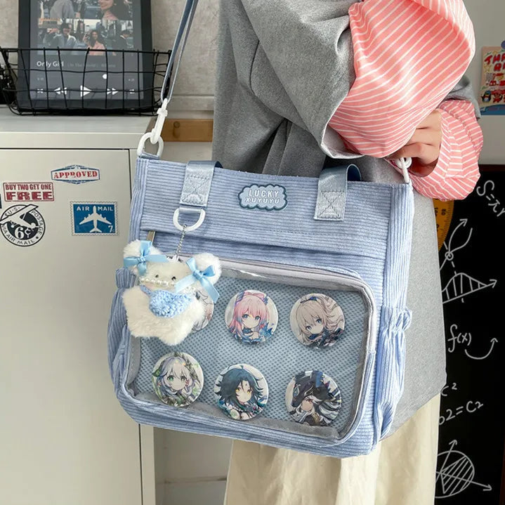 Person holding a blue Kawaii crossbody bag with anime-themed items