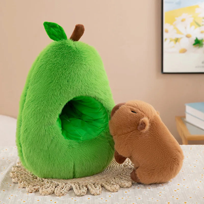Green kawaii plush avocado-shaped pet bed with a brown plush animal toy on a light surface.