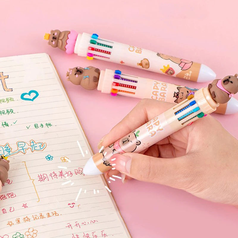 Colorful pens with kawaii cartoon animal ends held by a hand on a pink background